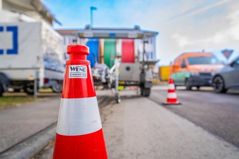 Traffic cone on a busy road with background traffic, Wend Glasfasermontage during the installation