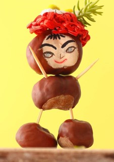 Funny chestnut figure with hat standing in front of a yellow wall, North Rhine-Westphalia, Germany,
