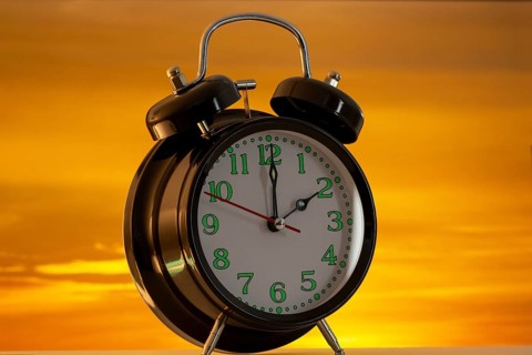 Symbolic image of the time change to summer time: close-up of an alarm clock in front of a