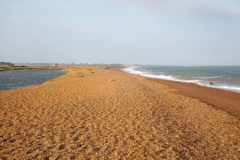 North Sea coastline view of shingle ridge and lagoon on beach bar, Shingle Street, East Lane,