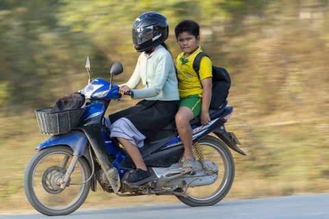 Mother with her son in school uniform on a motorbike, Vang Vieng, Vientiane province, Laos, Asia