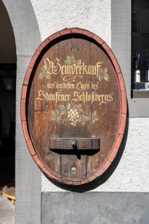 Old wine barrel on a house wall with artistic lettering and painting as a decorative advertising