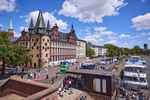 Saalhof with rent tower and excursion boats at the Mainkai under a blue sky with cumulus clouds in