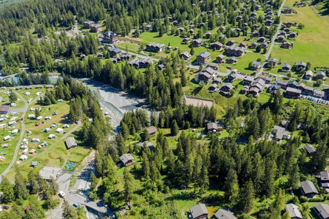 Drone shot, Camp site and village of La Fouly at a glacial river, holiday cottages, Switzerland,