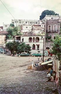 People and taxis at the Plaza bus stop, Hotel Colonia, Taxco, Guerrero state, Mexico, 1961, Central