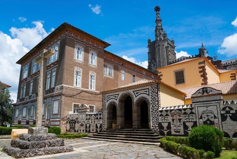 Eine historische Gebäudeansicht mit detaillierten Mosaikmustern und einem blauen Himmel im