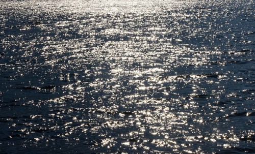 Sunbeams reflect glittering on water surface with high waves, Abstract background, Graphic