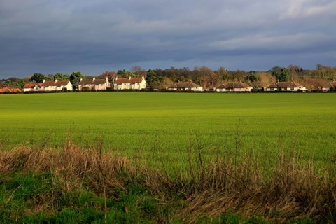 Houses spread out in a line in the linear village of Sutton, Suffolk, England, UK