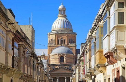 Traditional houses with balconies dome of Paola parish church, Tarxien town, near Valletta, Malta,