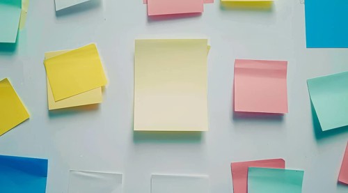 Three colourful post-it sticky notes are hanging on a white wall, AI generated