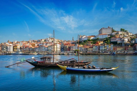 View of Porto city and Douro river with traditional boats with port wine barrels from famous