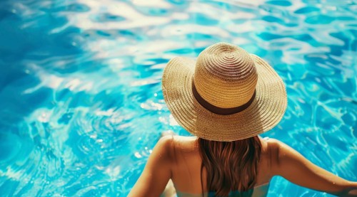 A woman in a straw hat and bikini top is swimming in a pool, AI generated