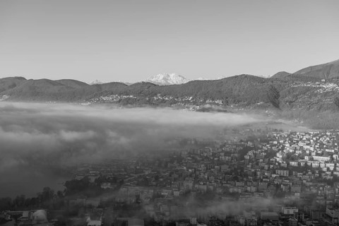 Snow-capped Mountain Peak Monte Rosa Above Cloudscape and Lake Lugano with Sunlight and Clear Sky