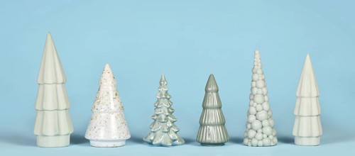 Banner with different shaped light green ceramic Christmas trees on blue background