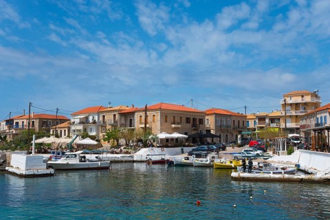 Harbour with boats and traditional buildings under a blue sky with some clouds, Agios Nikolaos,
