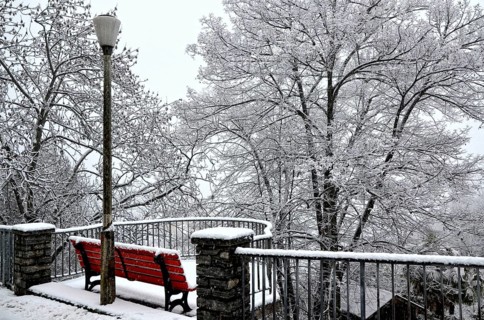 Beautiful Bench and Street Lamp with Bare Trees with Snow in Winter in Locarno, Ticino,