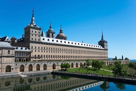 Historic stone monastery with reflection in the water and clear sky, Real Sitio de San Lorenzo de