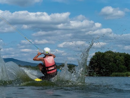 Young man jumping into the water with a wakeboard, Water ski and wake park, Water sports, Stráž pod
