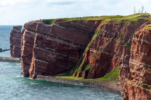 Red coloured sandstone, steep cliff coast of the offshore island of Heligoland, home of the