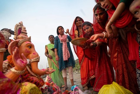 Devotees offer prayers to the Ganesha idol before immerse in the Brahmaputra river, during Ganesh
