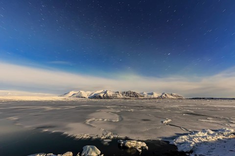 Night shot of an icy lake in front of Bergen, star trails, Vatnajökull, Jökulsarlon, Iceland,