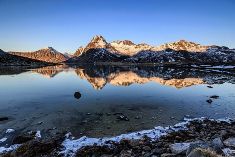 Fjord with steep snowy mountains, evening light, reflection, Flakstadoya, Lofoten, Norway, Europe