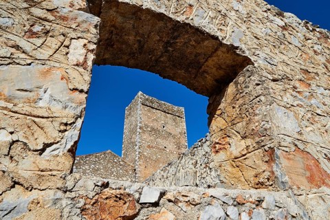 View through an arch of ruins to a clear sky and other stone structures, Flomochori, residential