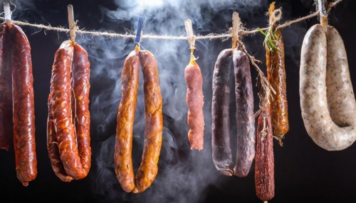 Food, various smoked sausages hanging on a string next to each other in the smoker, AI generated,