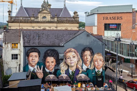 Mural on a building showing several young people in formal dress, Londonderry
