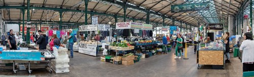 Lively marketplace under a large roof, filled with people and stalls, Belfast