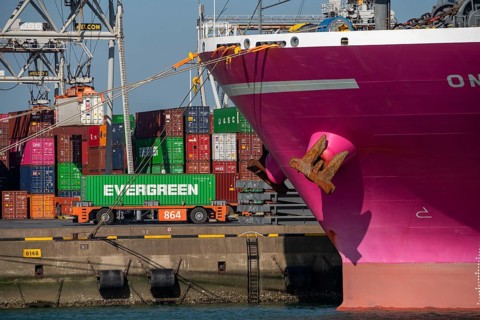 Self-driving, automated container transporters bring the containers to the loading and storage