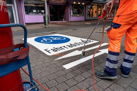 Application of road markings for a cycle lane, Rüttenscheider Straße in Essen, in the shopping and