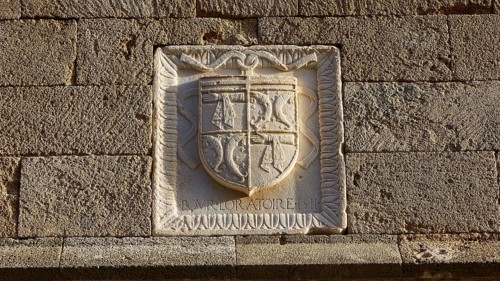 A coat of arms engraved in a stone wall with detailed historical patterns and text, Knights Street,