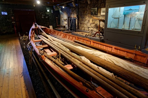 Long, narrow whaling boat in the whaling museum Lajes do Pico, with oars and harpoons, fishing