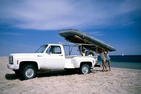 1977 GMC Sierra Super Custom 496 pickup truck vehicle two men unloading a rubber dinghy on the