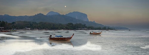 Before sunrise, longtail boats lie at low tide in the harbour at Sivalai Beach, Koh Mook Island,