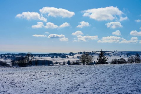 Bright winter landscape with clouds and a clear blue sky over snow-covered fields, Winter,