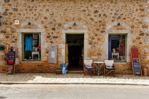 Façade with souvenir shop, typical stone house in Stoupa, former fishing village, Mani, Greece,