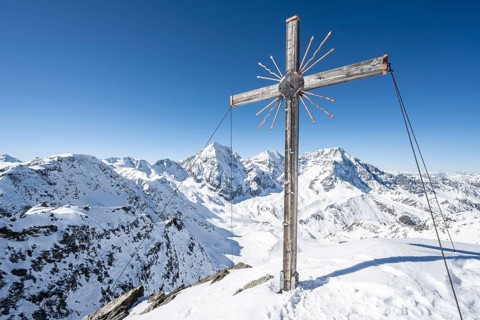 Summit cross at the summit of the Madritschspitze, mountain panorama with snow-covered mountain