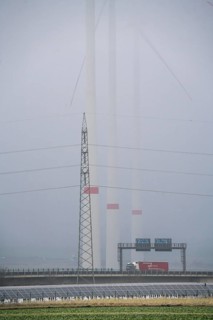 Wind farm in the fog, photovoltaic system, on the A44 motorway, dark doldrums, no wind no direct
