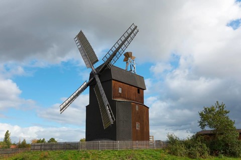 Historic wooden windmill under a cloudy sky in a landscape, Paltrock windmill, Parey, Elbe-Parey,
