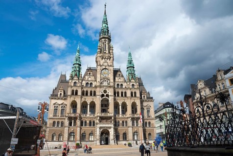 Gothic town hall with baroque architecture under a blue sky, people in the foreground, town hall,