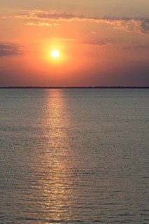 Sunset over the calm North Sea, the outline of the island of Juist on the horizon, Norddeich, Lower