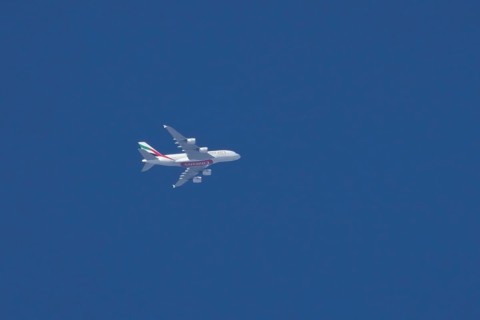 Airbus A380 jet aircraft of Emirates airlines flying in a blue sky England, United Kingdom, Europe