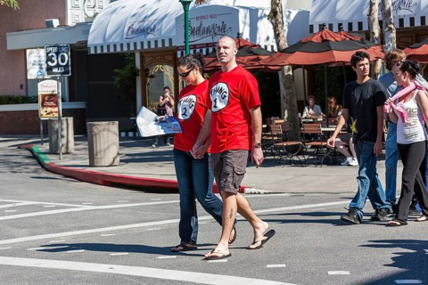 Young couple wearing Thing 1 and Thing 2 t-shirts walking on street in Universal Studios, Orlando,