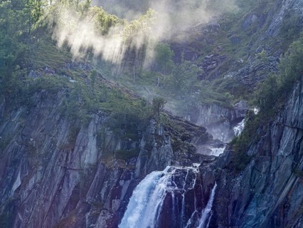 Sunbeams over waterfall Hivjufossen near Hovet, north of city Geilo, Norway, Europe