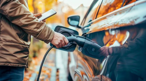 A man is charging his electric car, AI generated