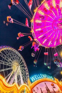 Chain carousel and Ferris wheel in the evening. 177th Cannstatter Volksfest at the Cannstatter