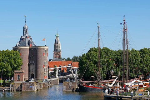 Town view of Enkhuizen with harbour entrance and historic old town with defence tower of