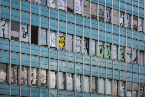 The logo of Berlin's public transport company BVG appears as graffiti on an empty office building